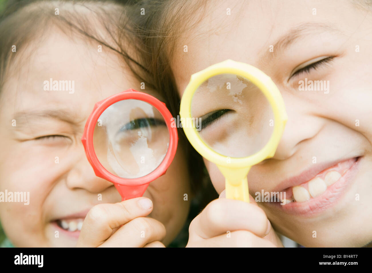 Girls holding magnifying glass, Chiba Prefecture, Honshu, Japan Stock