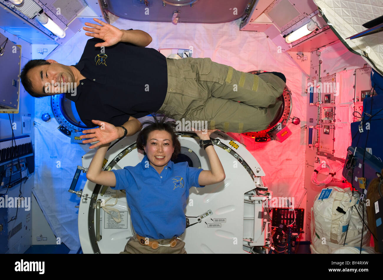 STS 131 Astronauts Soichi Noguchi & Naoko Yamazaki in laboratory of International Space Station docked to Shuttle Discovery Stock Photo