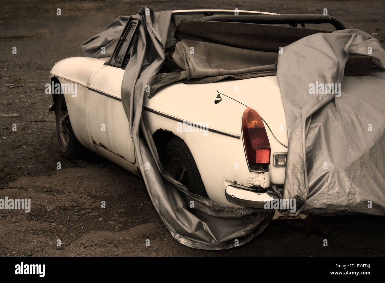 An old classic MG white car covered up and ready to be repaired as a restoration project Stock Photo