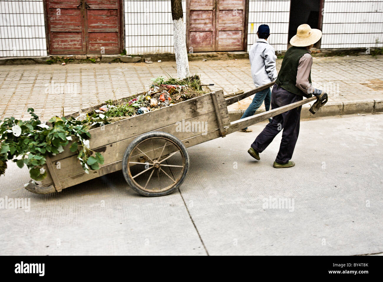 CHINA, YICHANG, SANDOUPING: Street scene of elderly farm woman and her daughter pulling a wooden cart Stock Photo