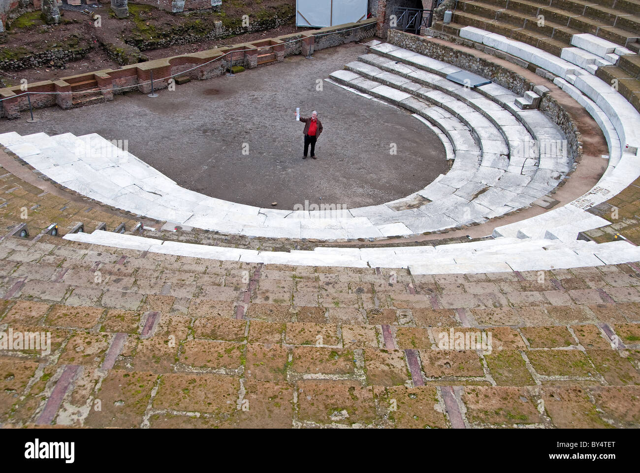 Man standing centre stage of the Teatro Grande, or large Theater, Pompeii, Naples Stock Photo