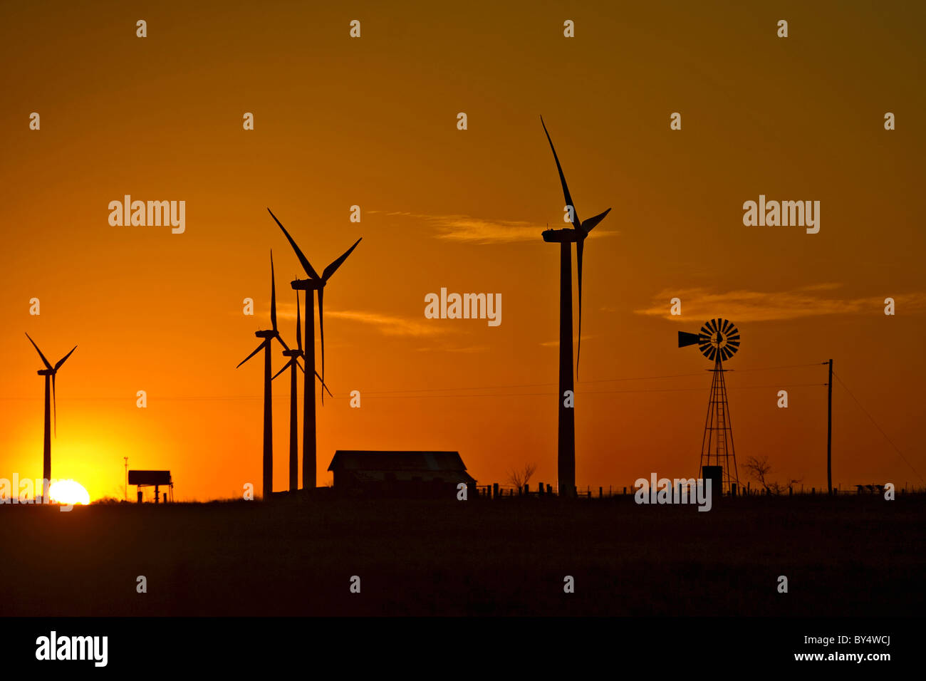 Wind generators and a wind mill dot the morning sky in west Texas USA Stock Photo