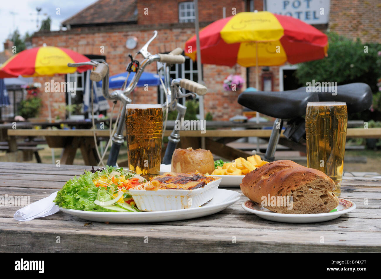 Two cyclists stop for a tasty lunch and pints of lager in the country pub garden of the  Flower Pot Hotel, Aston, Henley-on-Thames, Berkshire,UK Stock Photo