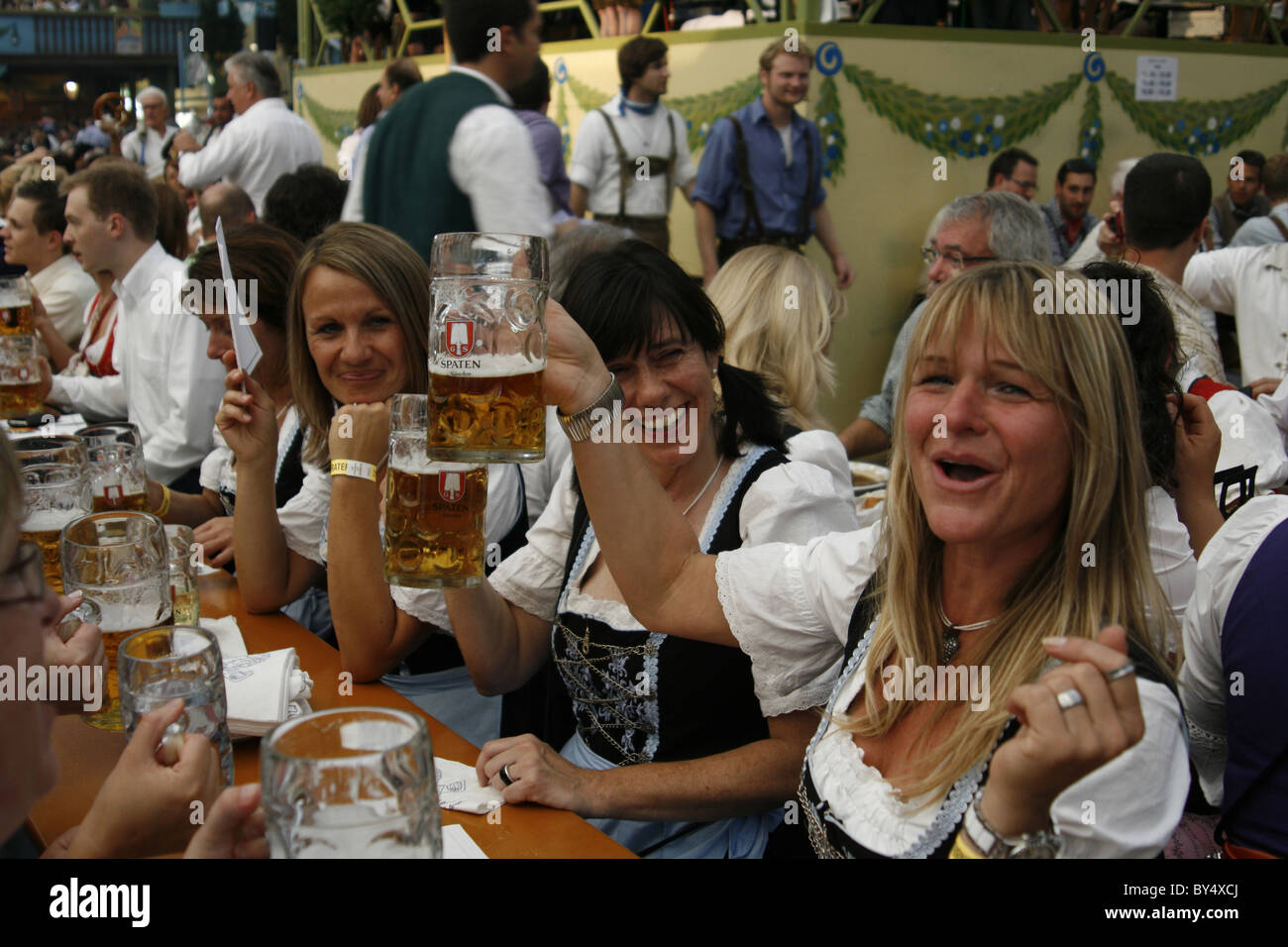 Germany Bavaria Munich Octoberfest women in Bavarian costume enjoying a beer in an Oktoberfest beerhall Stock Photo