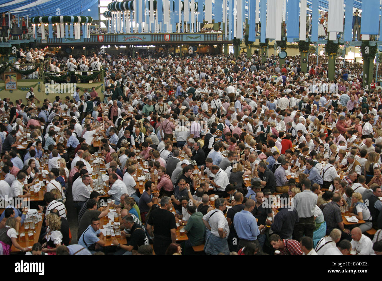 Germany Bavaria Munich Octoberfest large crowd group men and women in Bavarian costume enjoying beer in an Oktoberfest beerhall Stock Photo