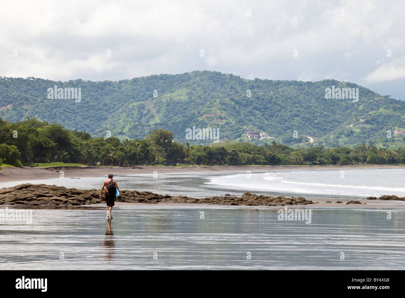 Man walking along the beach in Playas del Coco in Guanacaste Province, Costa Rica. Stock Photo