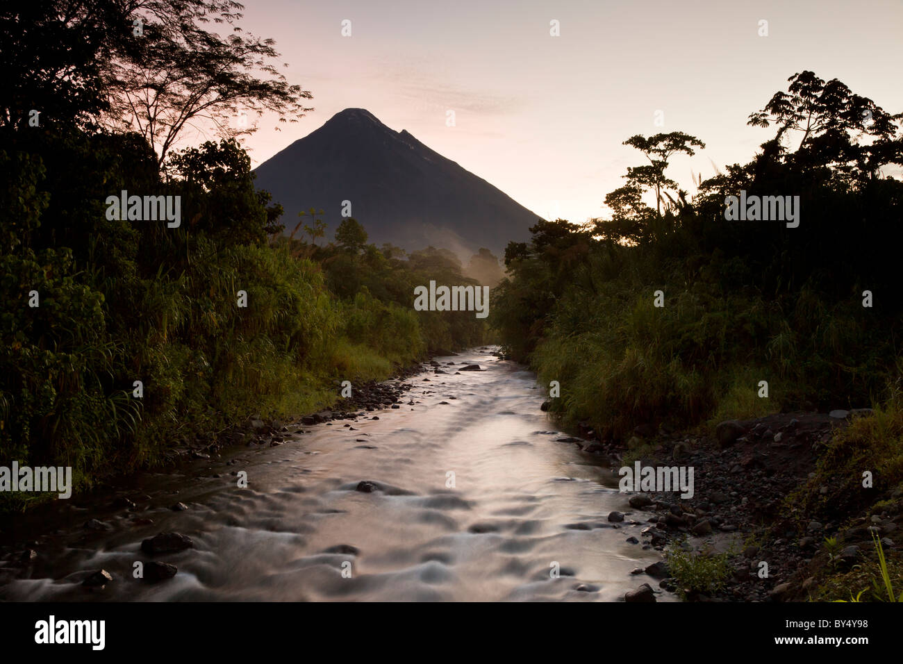 Sunrise at Tabacon river and Costa Rica's most active volcano The Arenal Volcano in Arenal National Park, Alajuela, Costa Rica. Stock Photo
