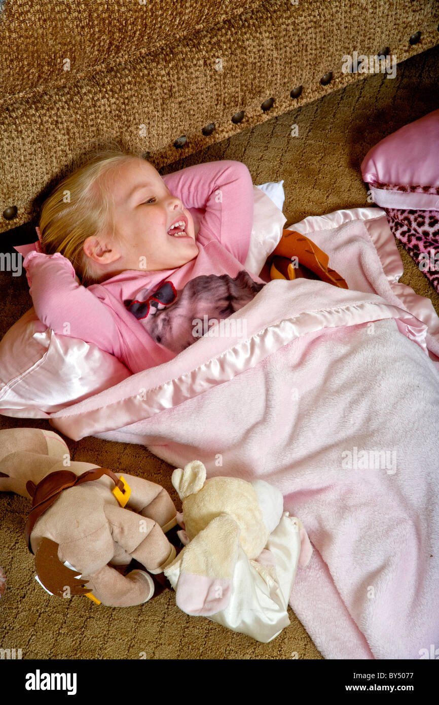 A happy girl beds down for a sleepover in a special junior size sleeping bag in Southern California. Stock Photo