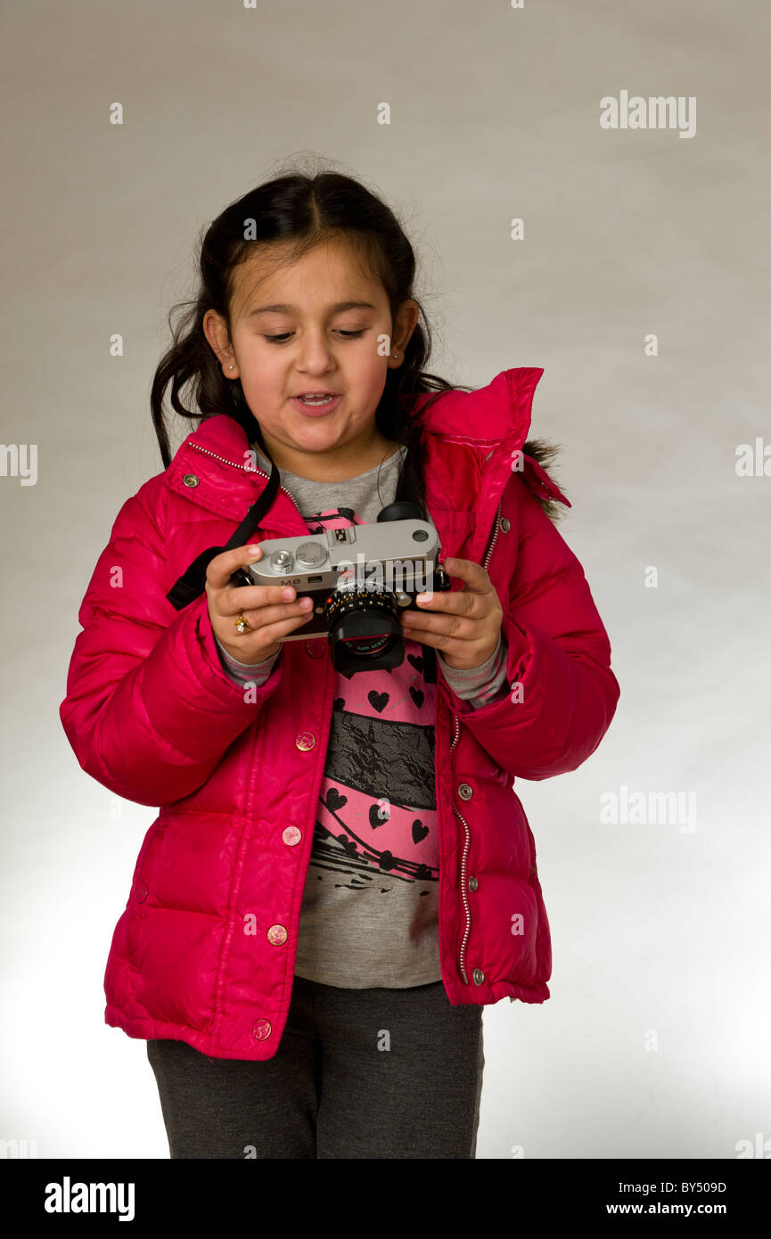 Young girl with camera looking at the LCD screen Stock Photo