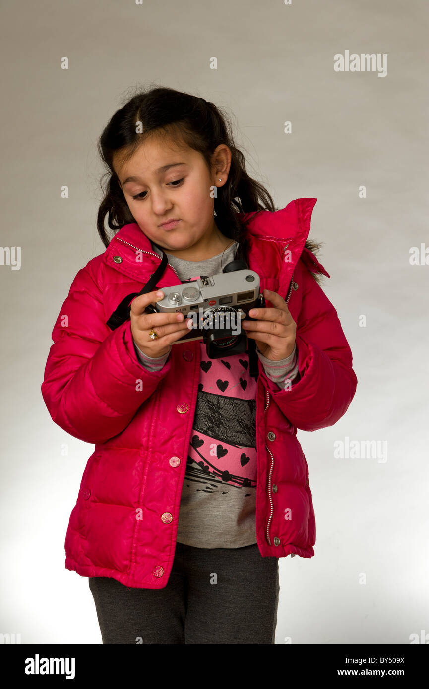 Young girl with camera looking at the LCD screen Stock Photo