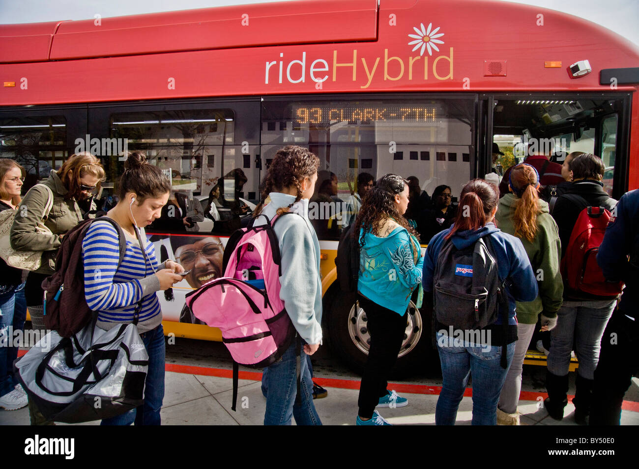 Hispanic community college students board a hybrid city bus in Long Beach, CA. Stock Photo