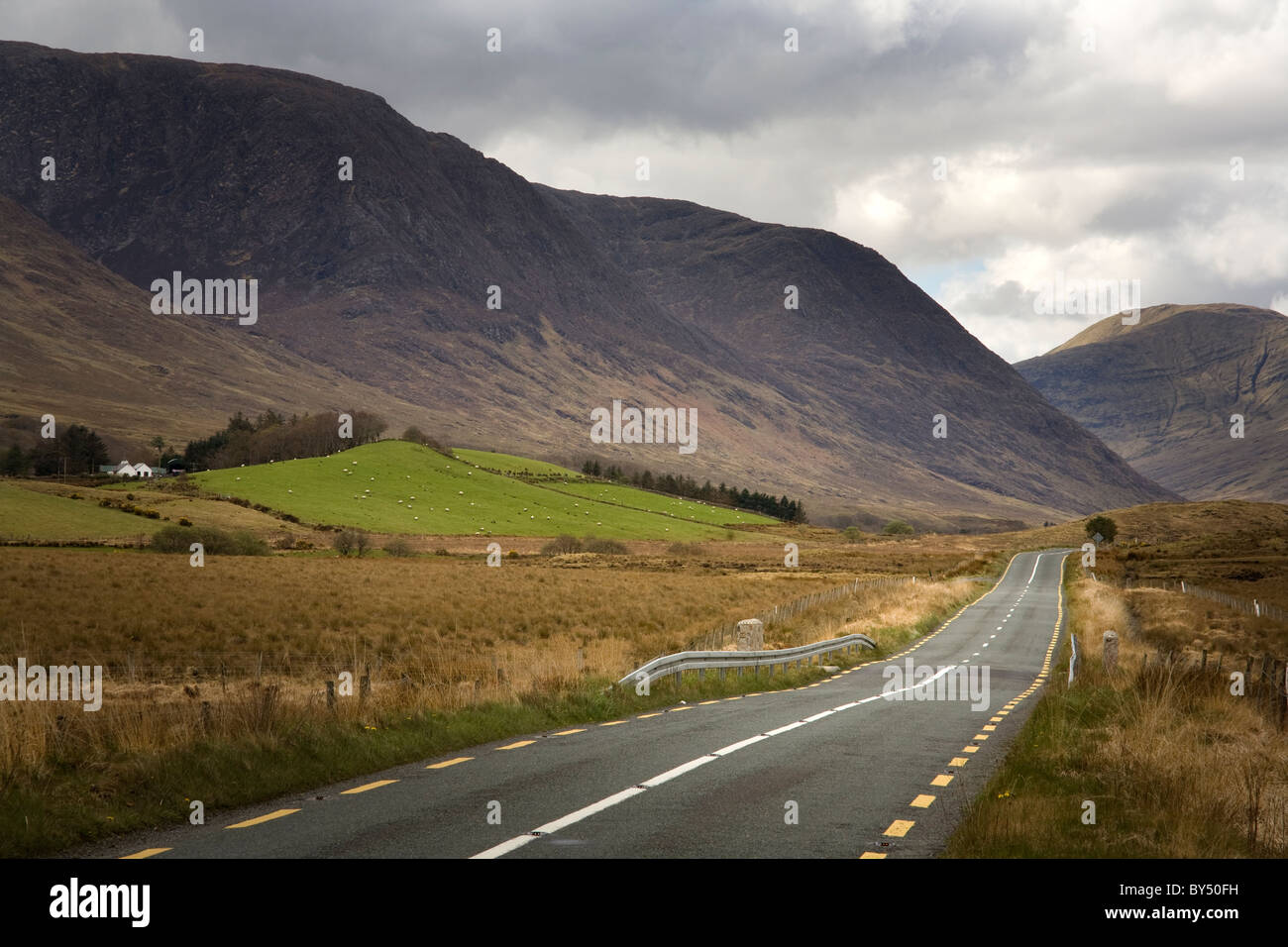 A road running towards mountains through Connemara National Park, Ireland Stock Photo