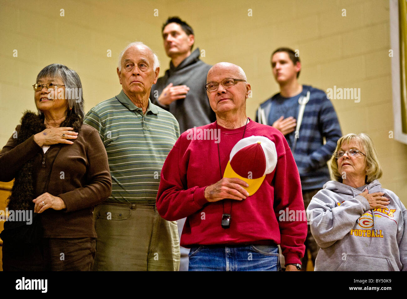 With one sour exception, students and staff make the Pledge of Allegiance  basketball game in a gymnasium in Southern California Stock Photo