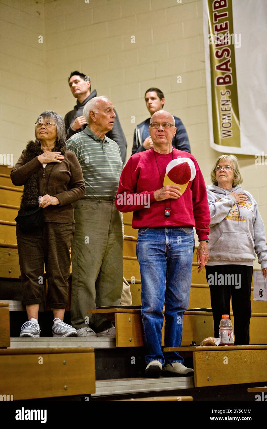 With one sour exception, students and staff make the Pledge of Allegiance  basketball game in a gymnasium in Southern California Stock Photo