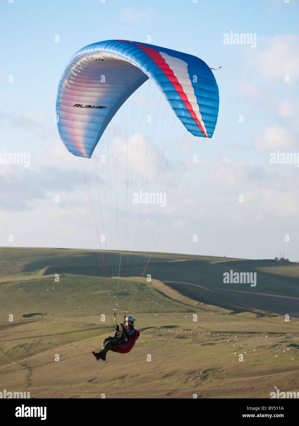Pilot flying his Ozone Rush Paraglider at Milk Hill near Marlborough, Wiltshire England Stock Photo