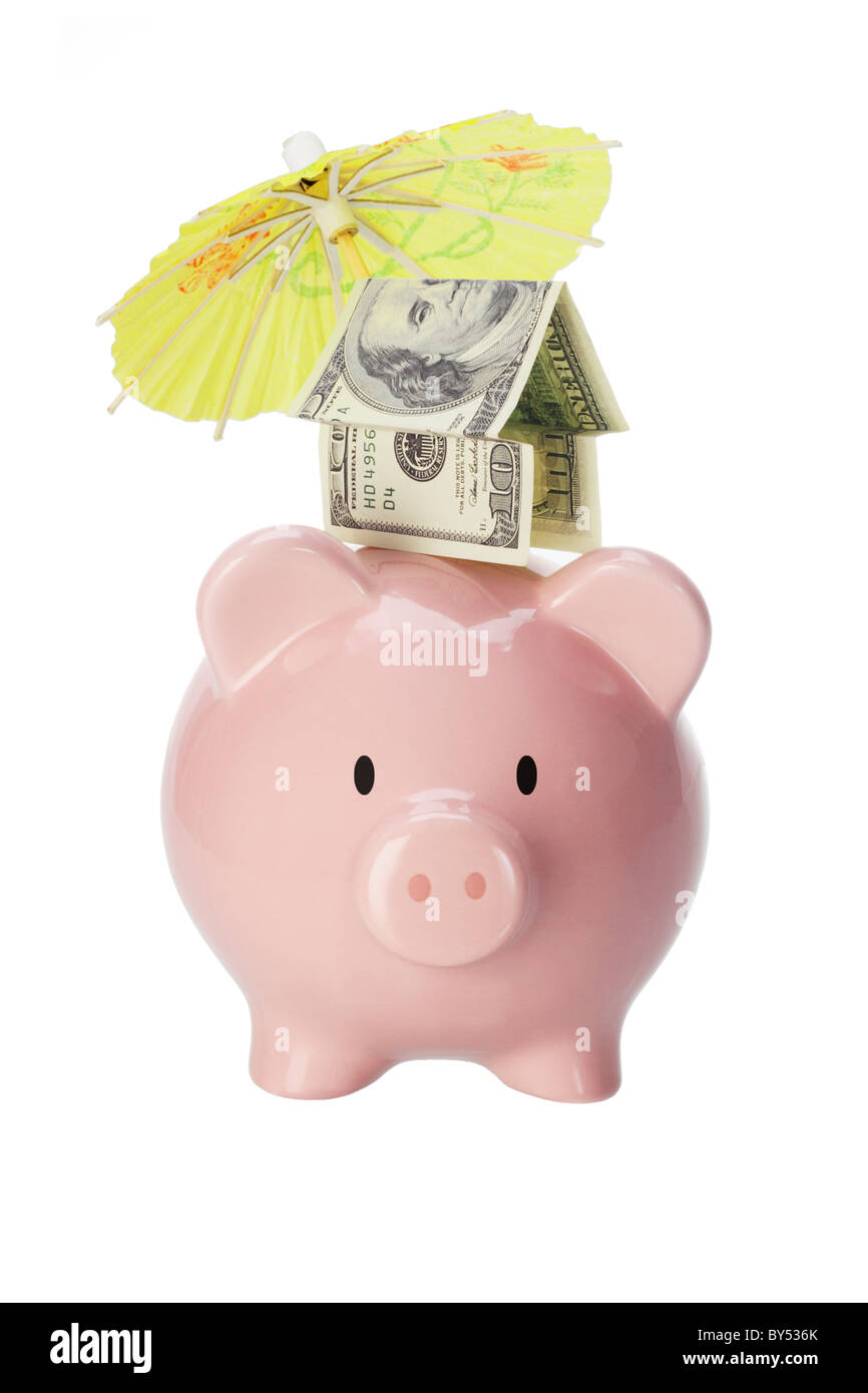 Protection and of invesments - Piggy bank with colorful umbrella and money house on white background Stock Photo