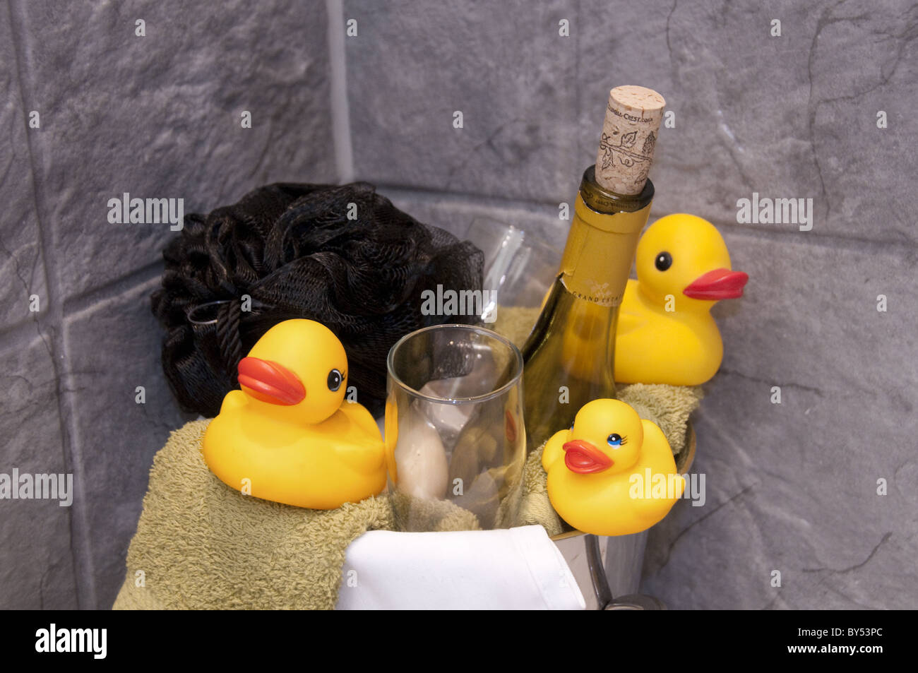 Rubber duckies and champagne bottle, glasses in bathroom Stock Photo