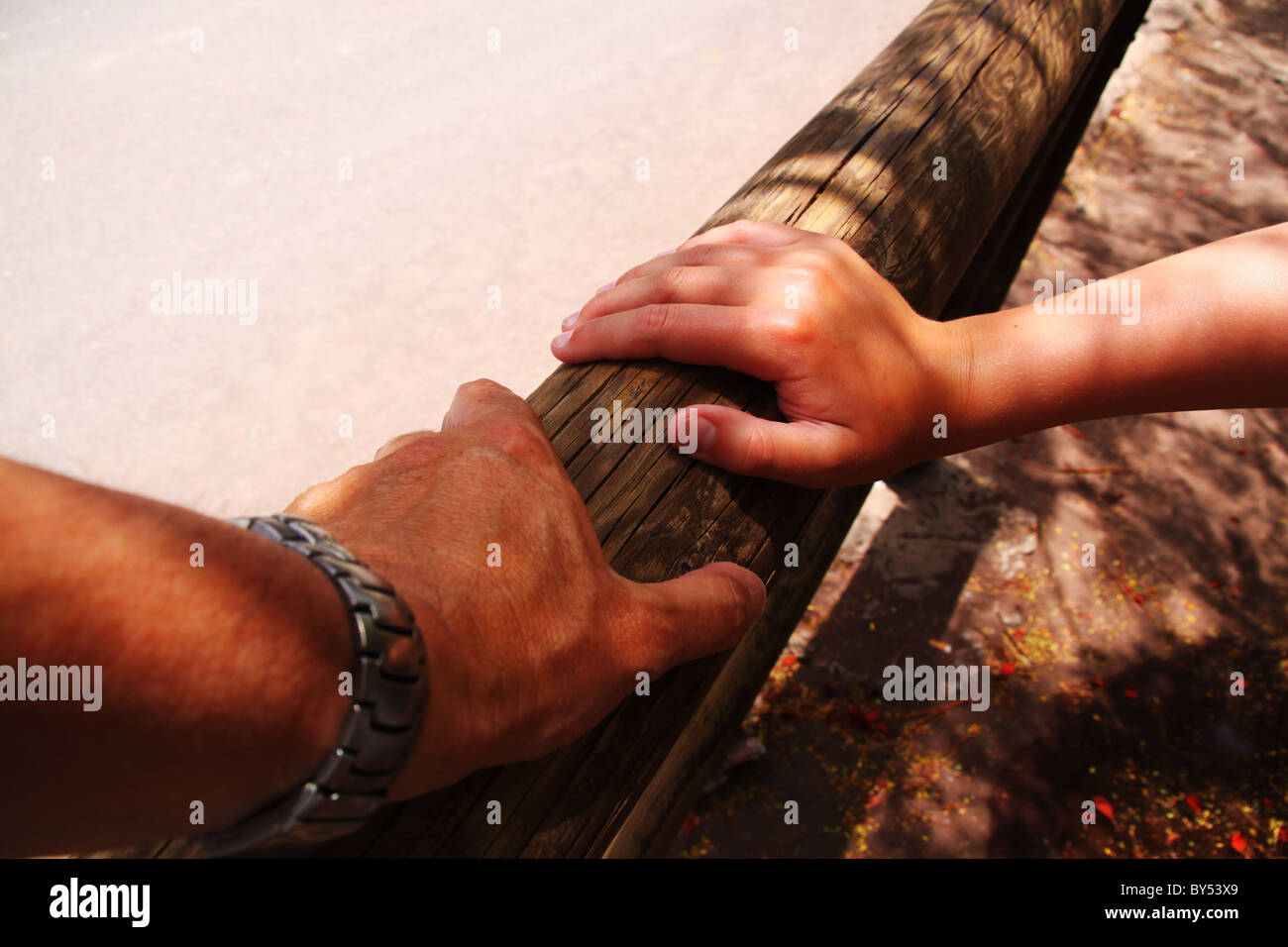 Man and child hand on wooden rail Stock Photo