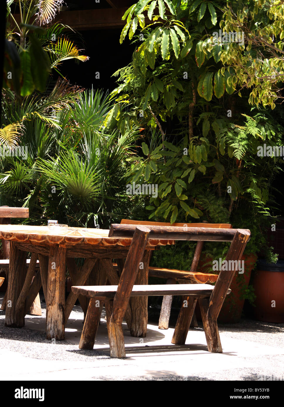 Wooden outdoor table at restaurant in tropical park Stock Photo