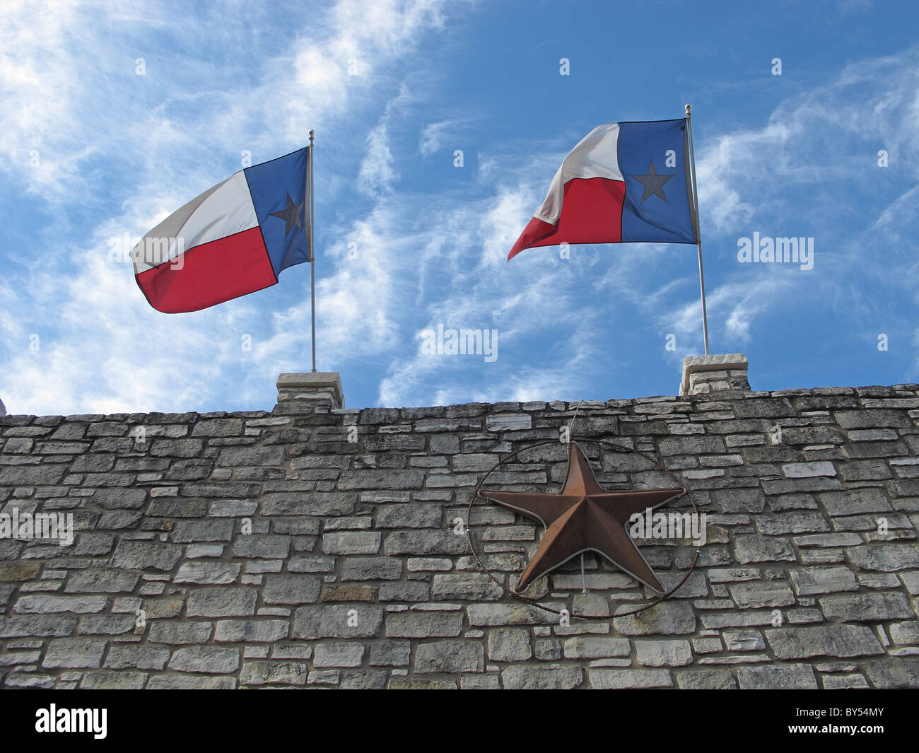 Texas flags and blue skies and clouds Stock Photo