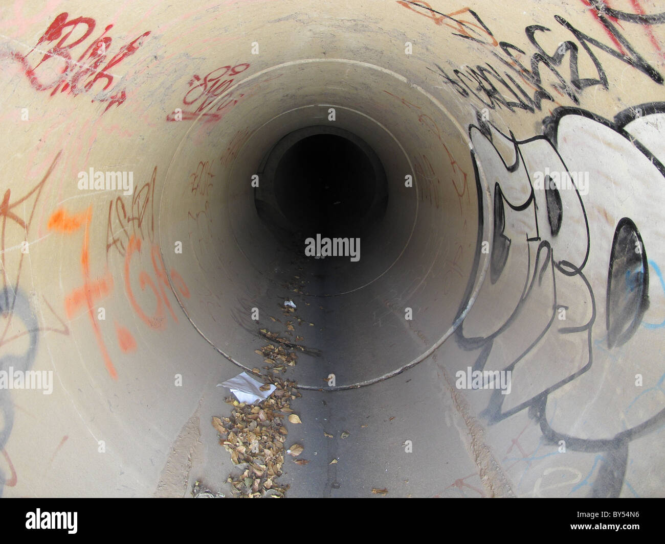 Sewer tunnel with graffiti Stock Photo