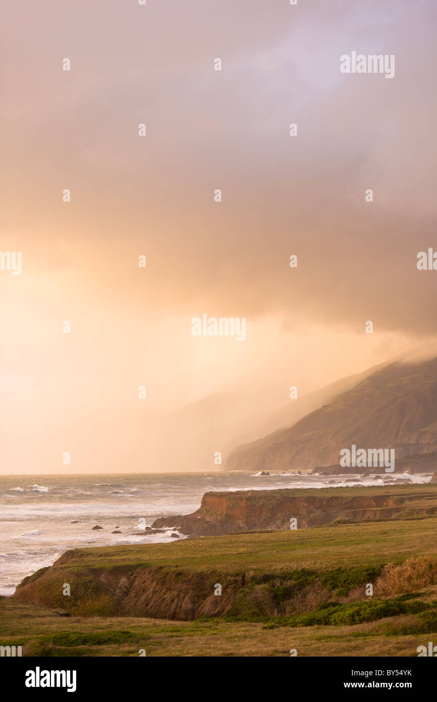 A stormy Pacific Ocean crashes against the rocky coast of Central California along the Pacific coast highway at sunset, San Simeon. Stock Photo