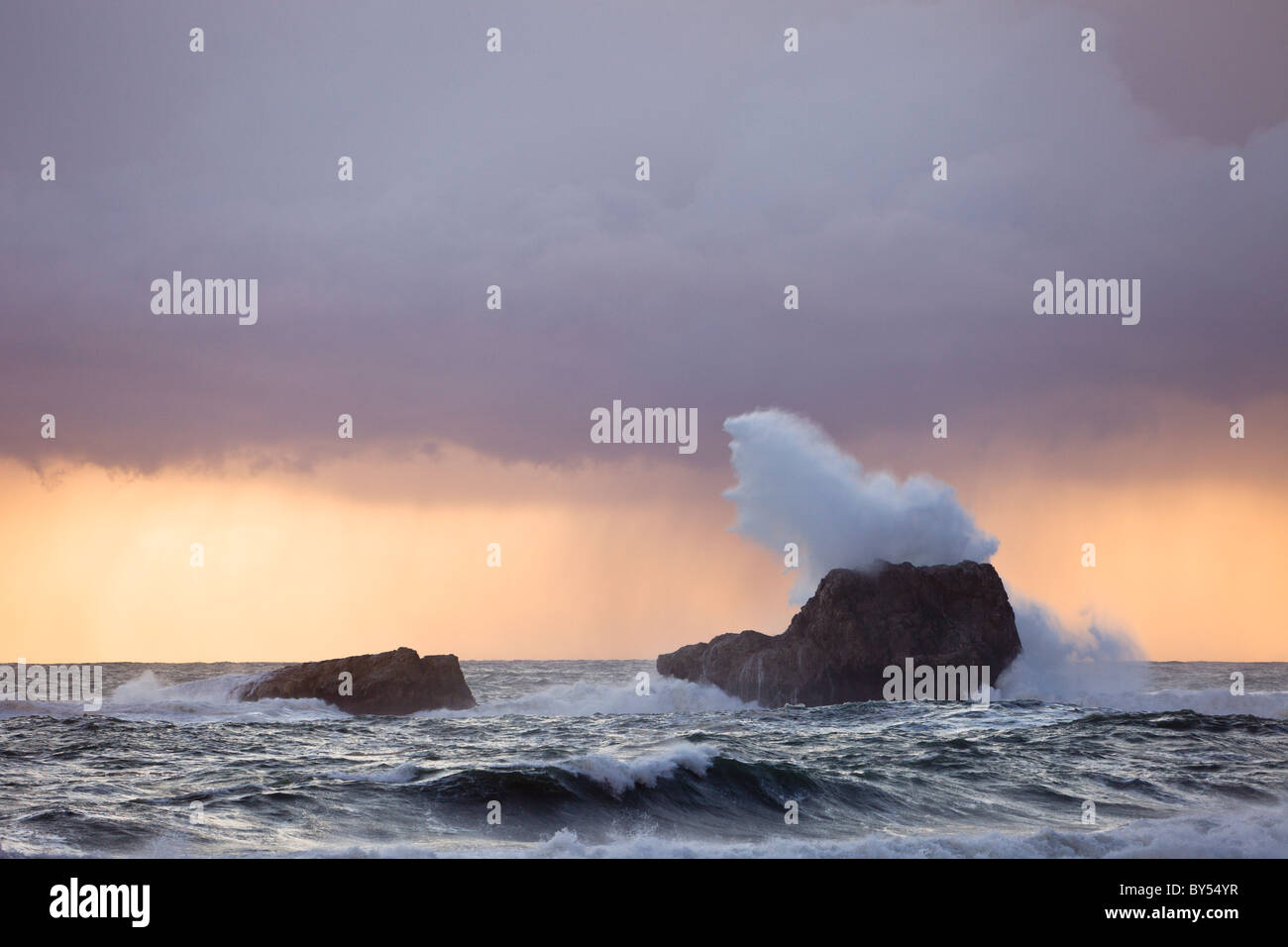 A stormy Pacific Ocean crashes against rocks along the Central California Coast at San Simeon. Stock Photo