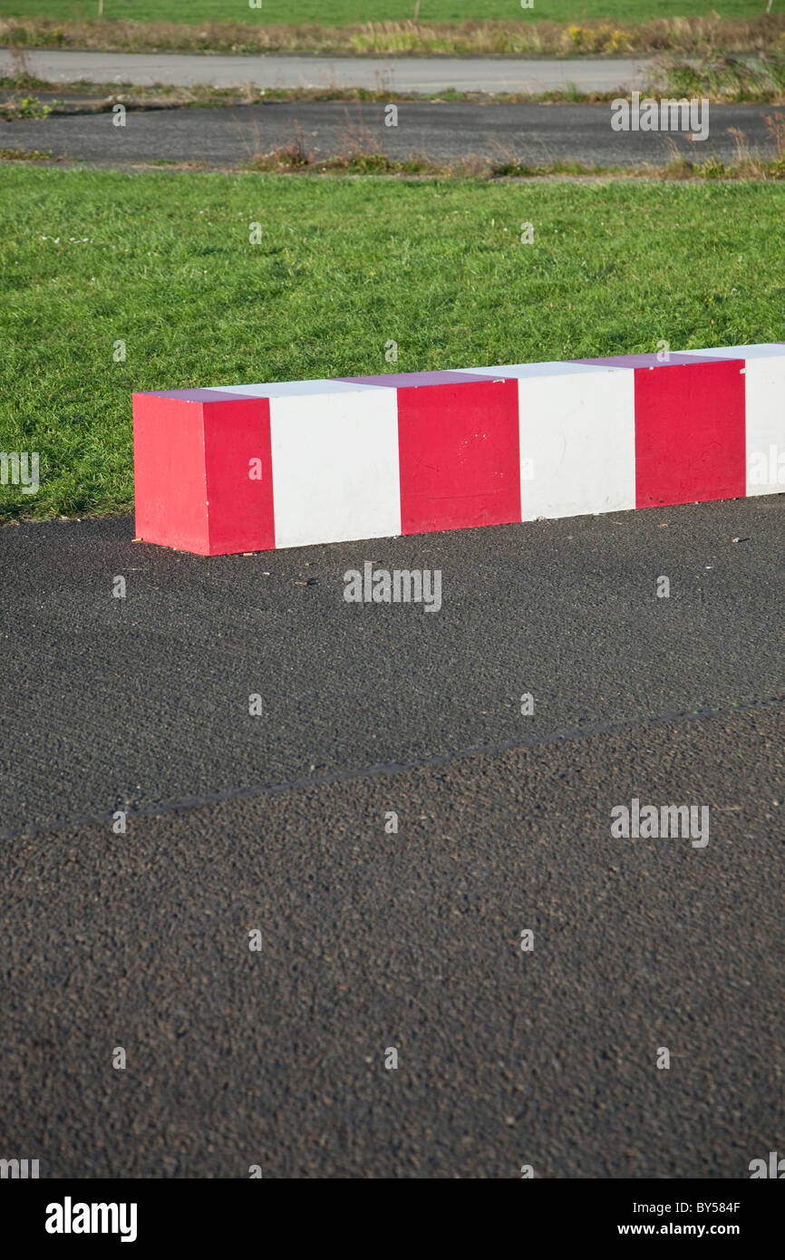 Striped concrete barrier in a parking lot Stock Photo - Alamy