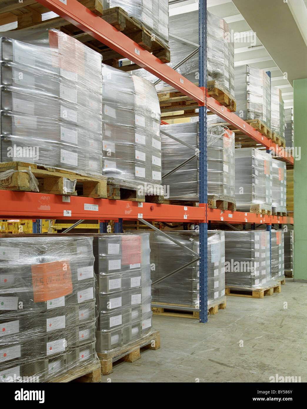 Pallets stacked in a warehouse Stock Photo - Alamy