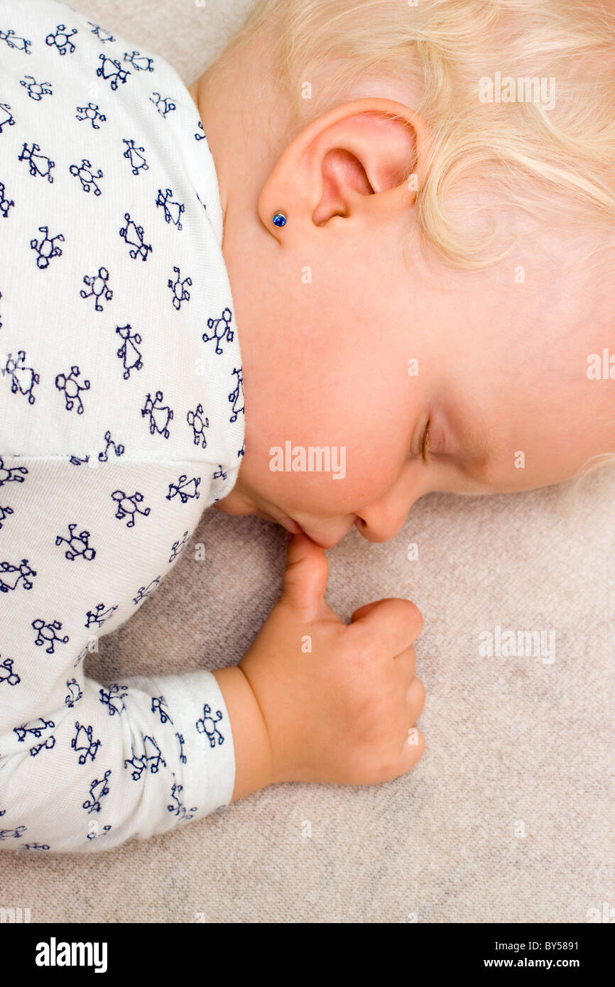 Sleeping baby girl with finger in mouth, 1 year old Stock Photo