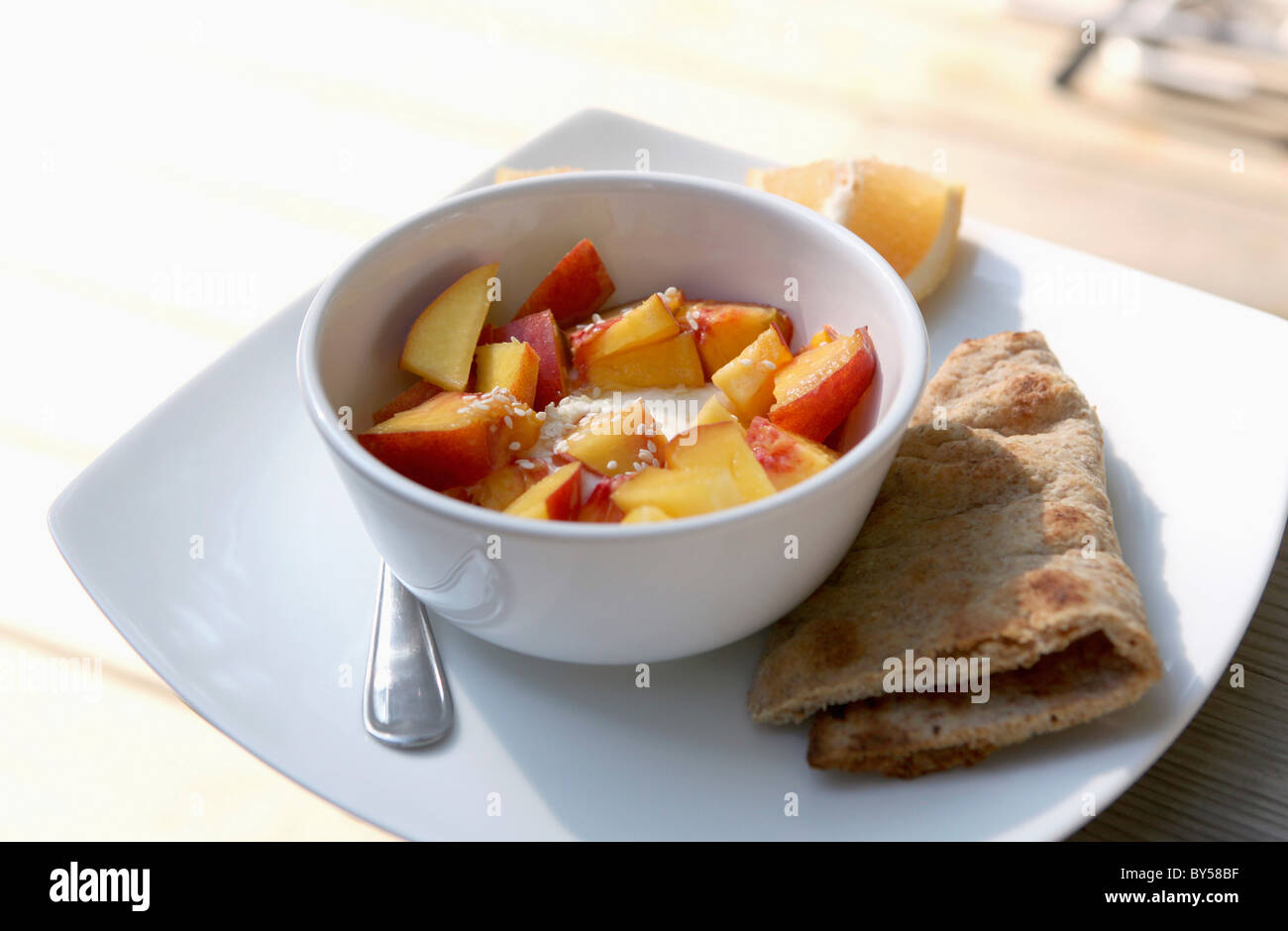 A bowl of yogurt with fresh nectarines Stock Photo