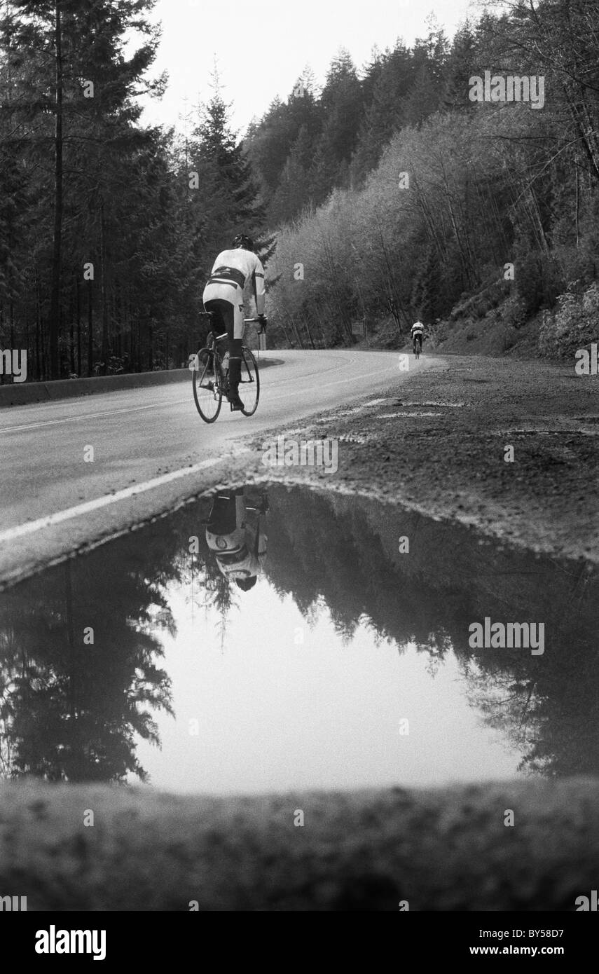 A man on a racing bicycle cycling up a mountain road Stock Photo