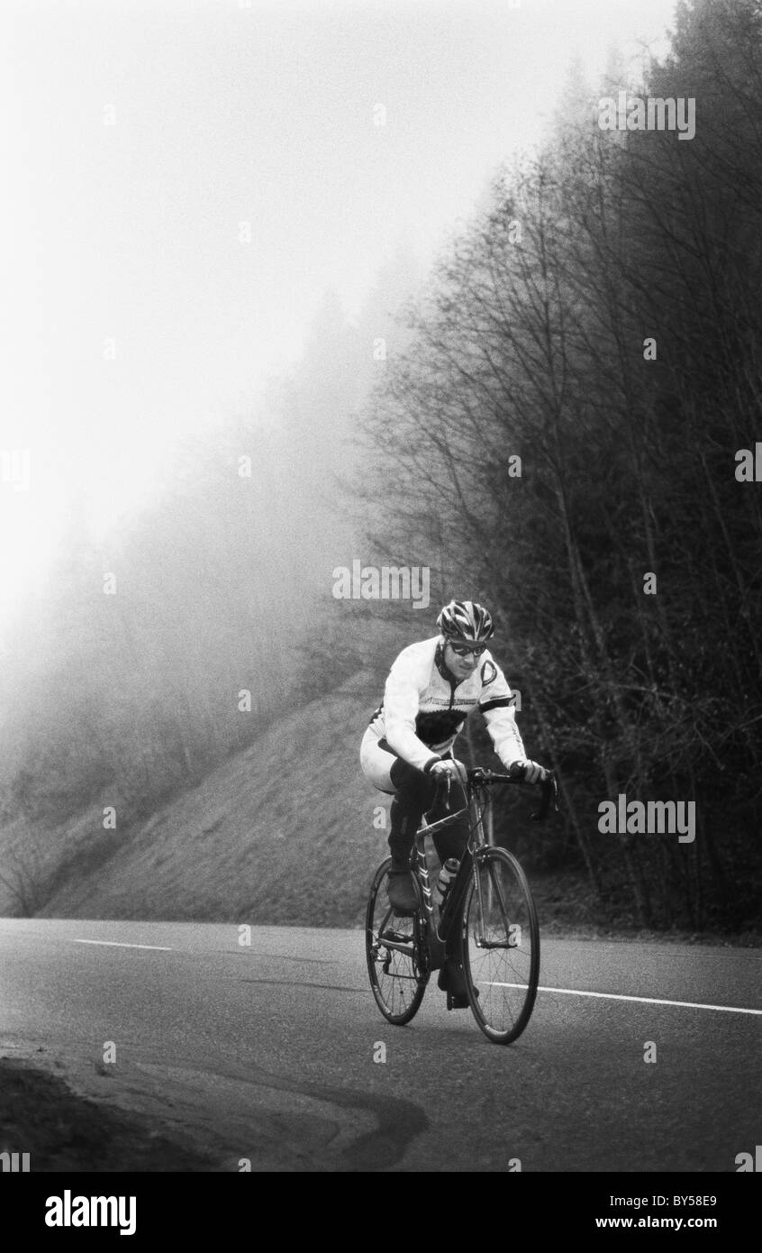 A man on a racing bicycle cycling up a mountain road Stock Photo