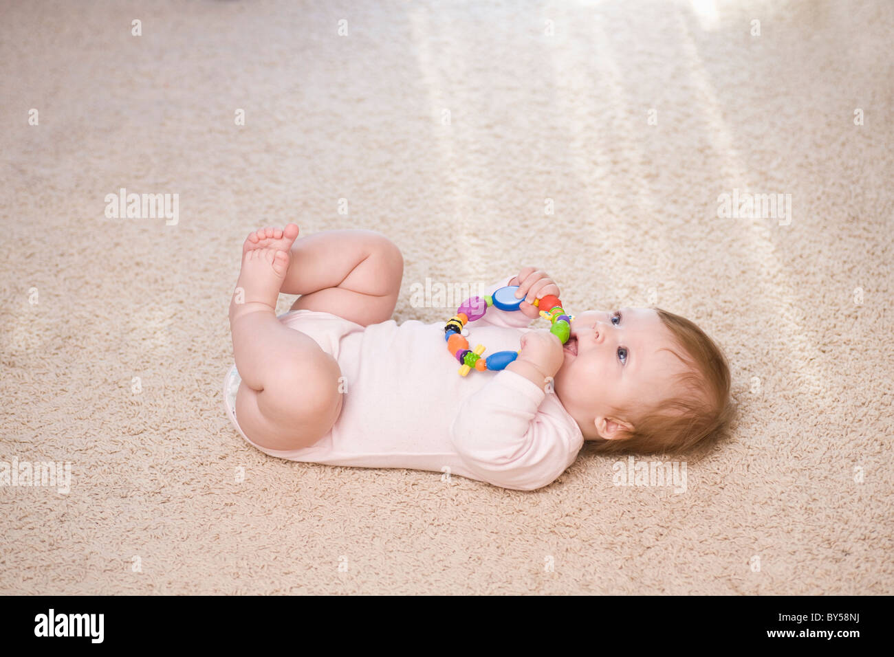 A baby biting a teething ring Stock Photo