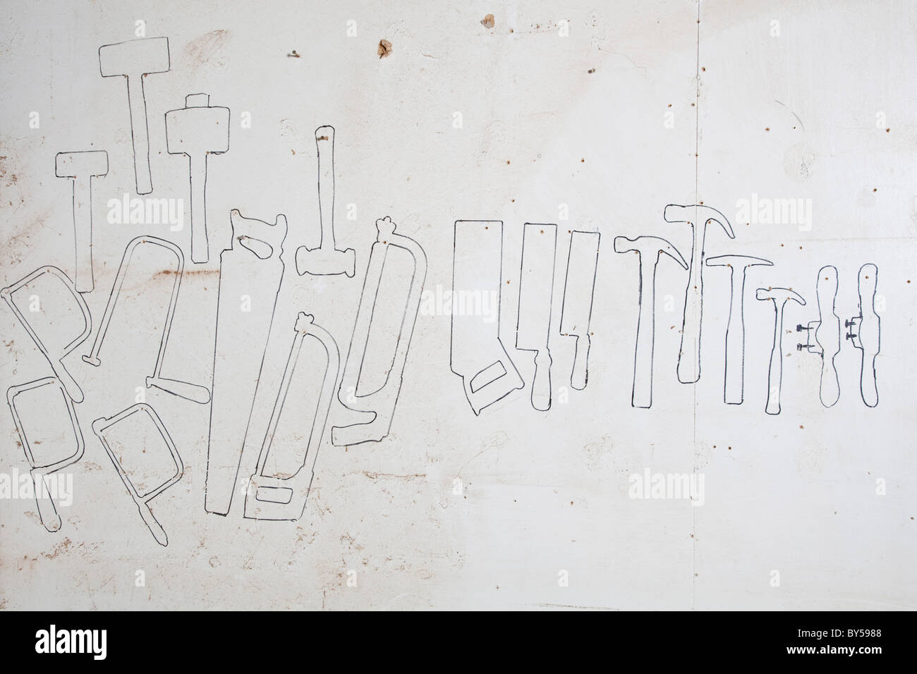 Drawn outlines of hand tools on a wall Stock Photo