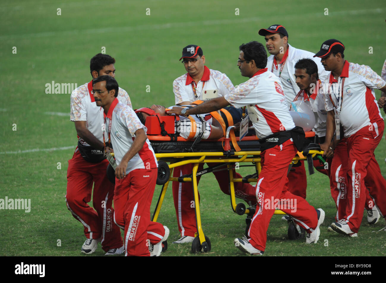 India Delhi 2010 XIX Commonwealth Games Rugby Sevens injured player being taken off the pitch on wheeled stretcher. Stock Photo