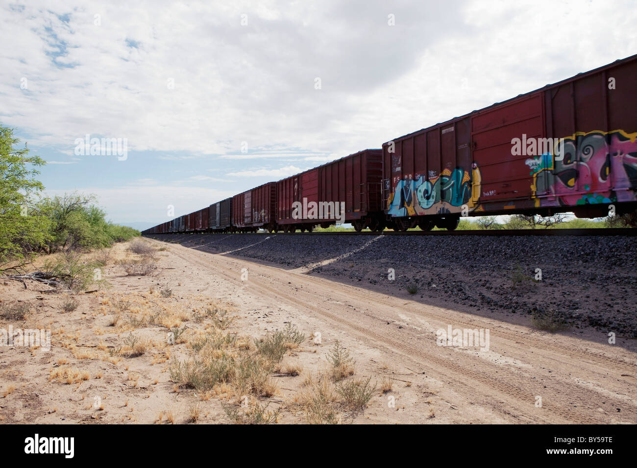 Freight train next to a dirt road Stock Photo Alamy
