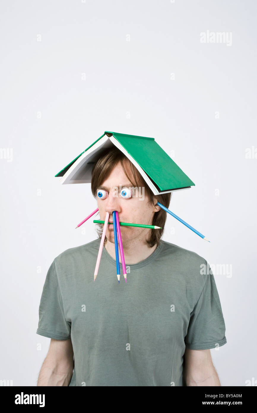 Bizarre man balancing book on head Stock Photo Alamy