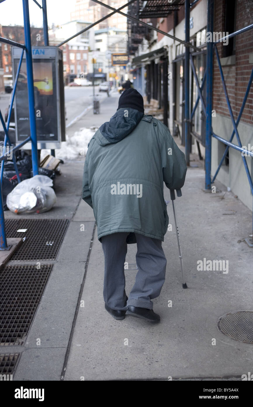 Elderly man with a cane making his way down the sidewalk in Manhattan, NYC Stock Photo