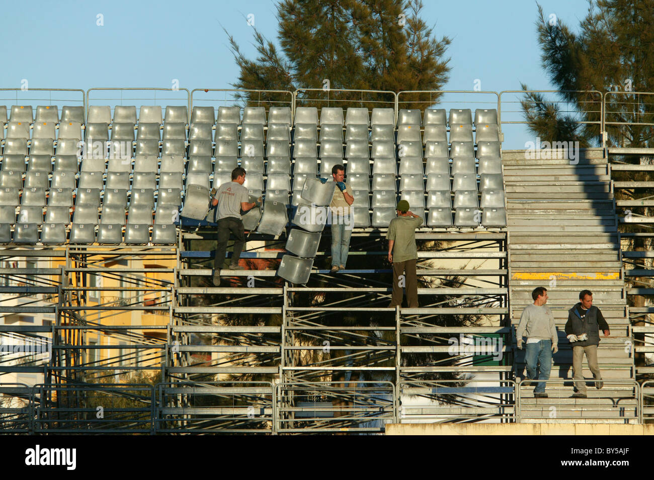 Men installing seats at a football stadium Stock Photo