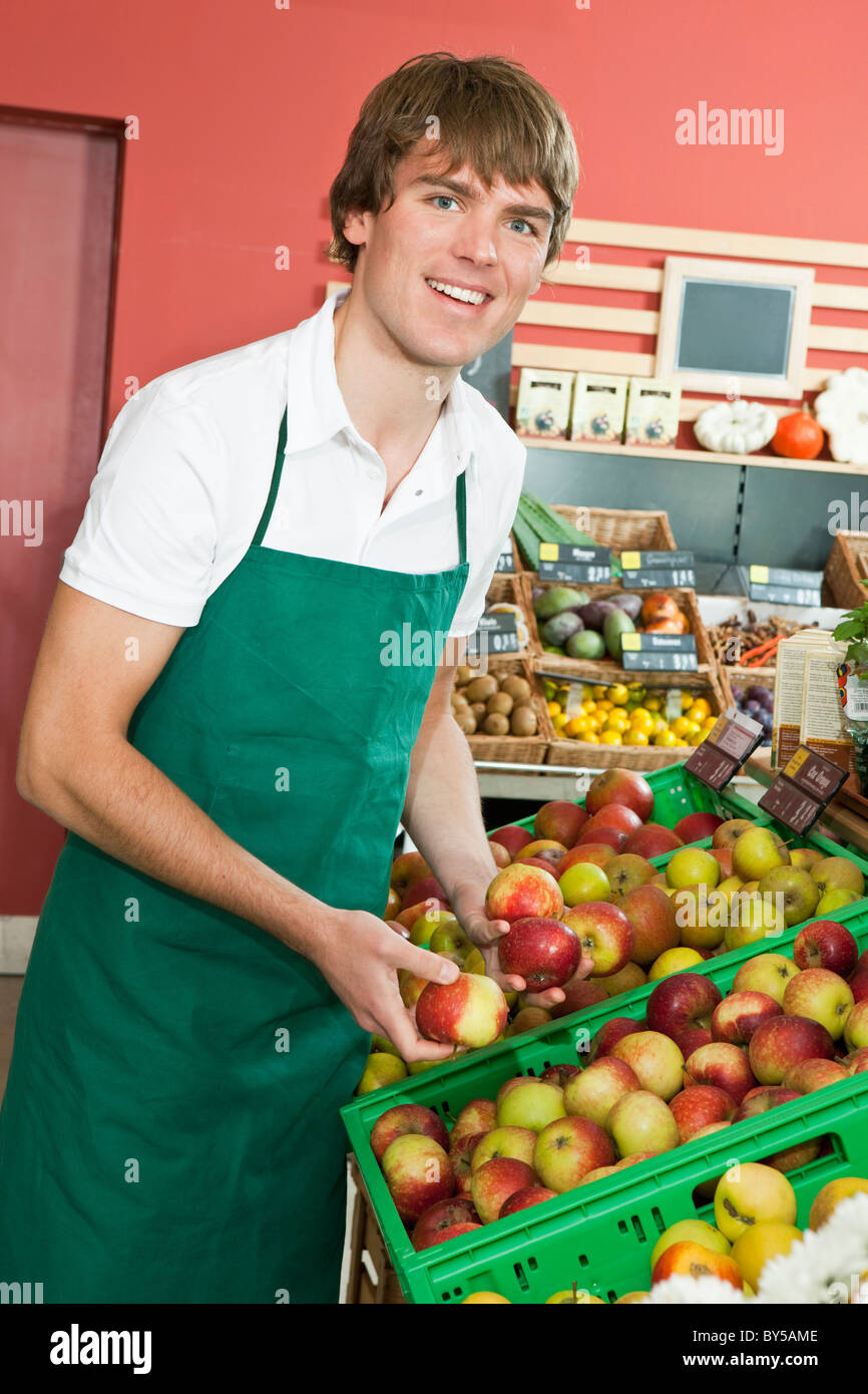 A grocery stocker stocking apples Stock Photo Alamy