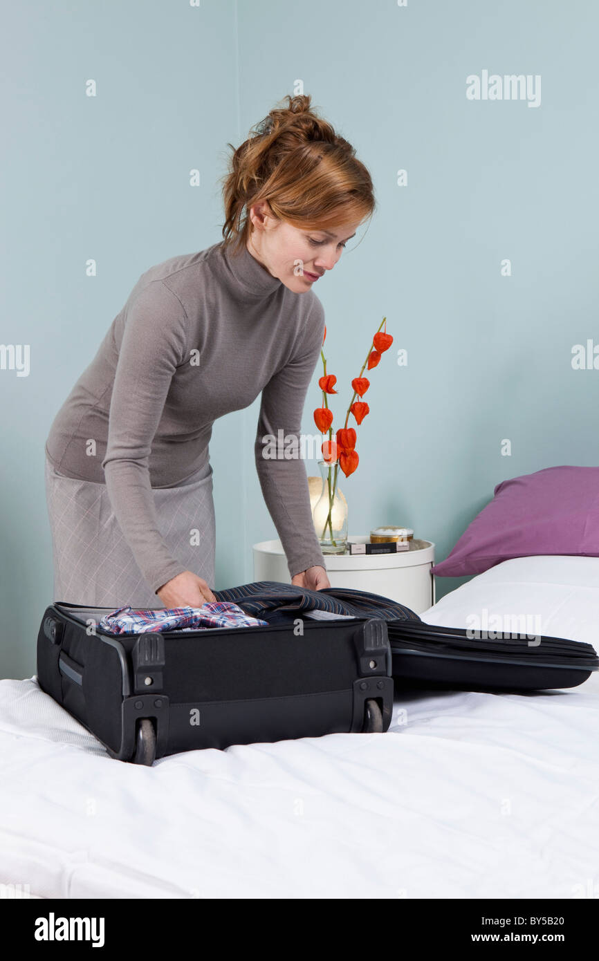 A woman packing a suitcase Stock Photo - Alamy