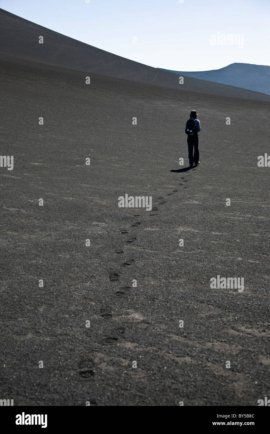 Rear view of a woman walking over Lonquimay Volcano, Patagonia, Chile Stock Photo