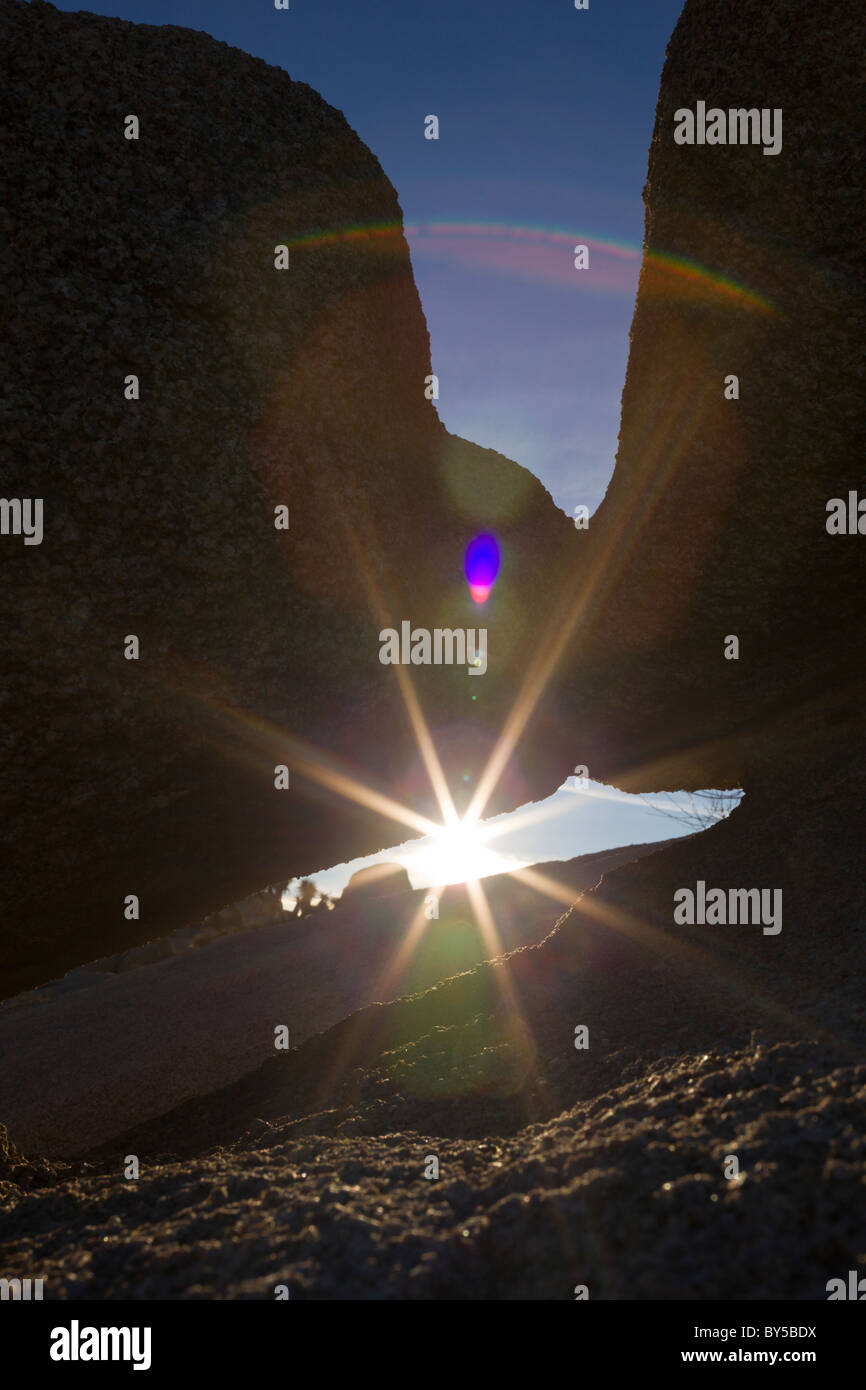 Sunlight shines through granite rock formations in Joshua Tree National Park, California, USA. Stock Photo