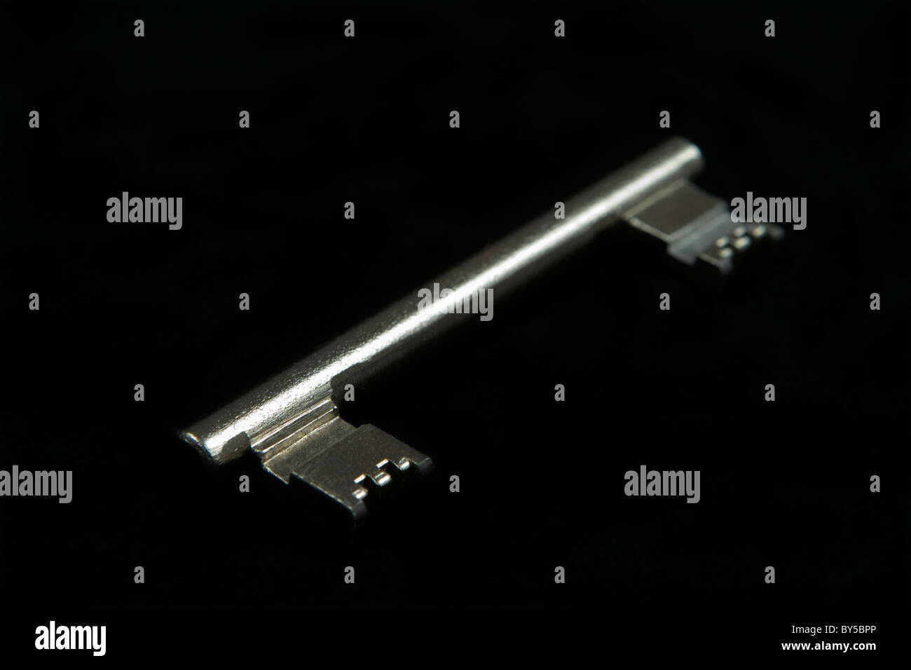 A double-ended key, black background Stock Photo