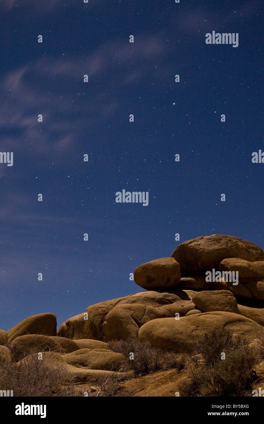 Starry night sky with moonlight illuminating granite boulders at Joshua ...