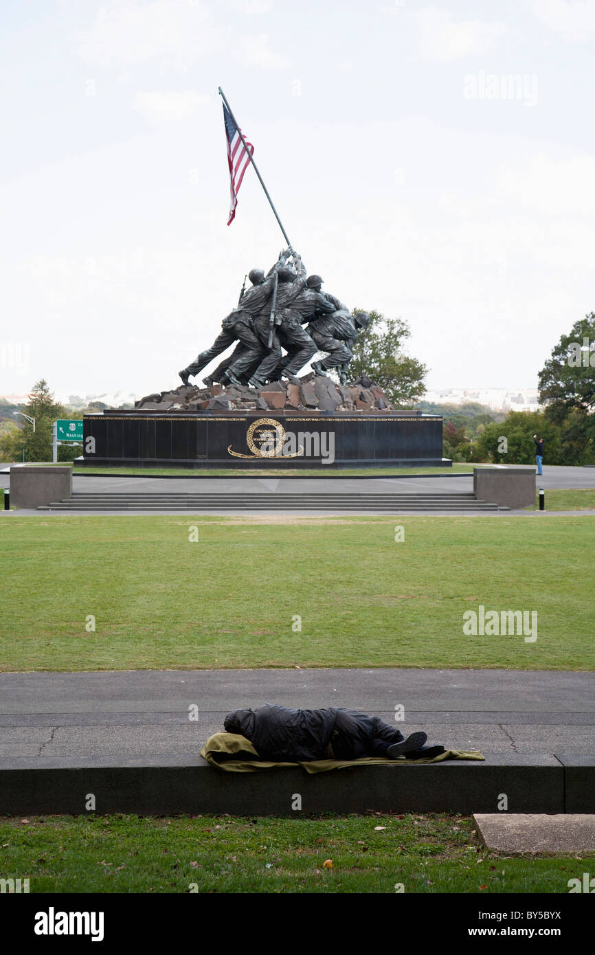 A homeless man sleeping in front of the Iwo Jima Memorial Stock Photo
