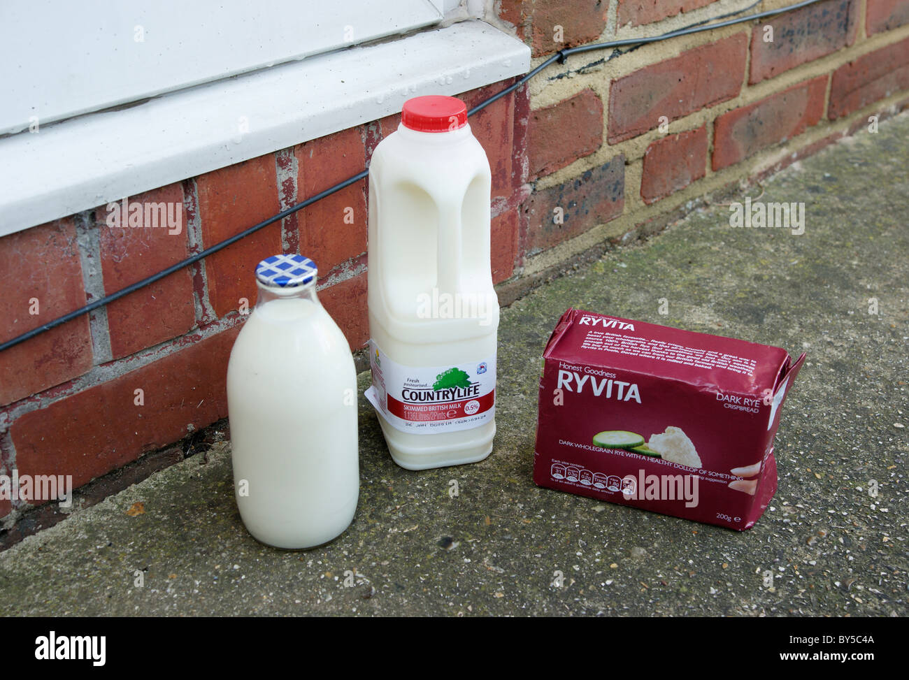 plastic container & glass bottle of skimmed milk, & pack of ryvita, doorstep delivery from the milkman Stock Photo