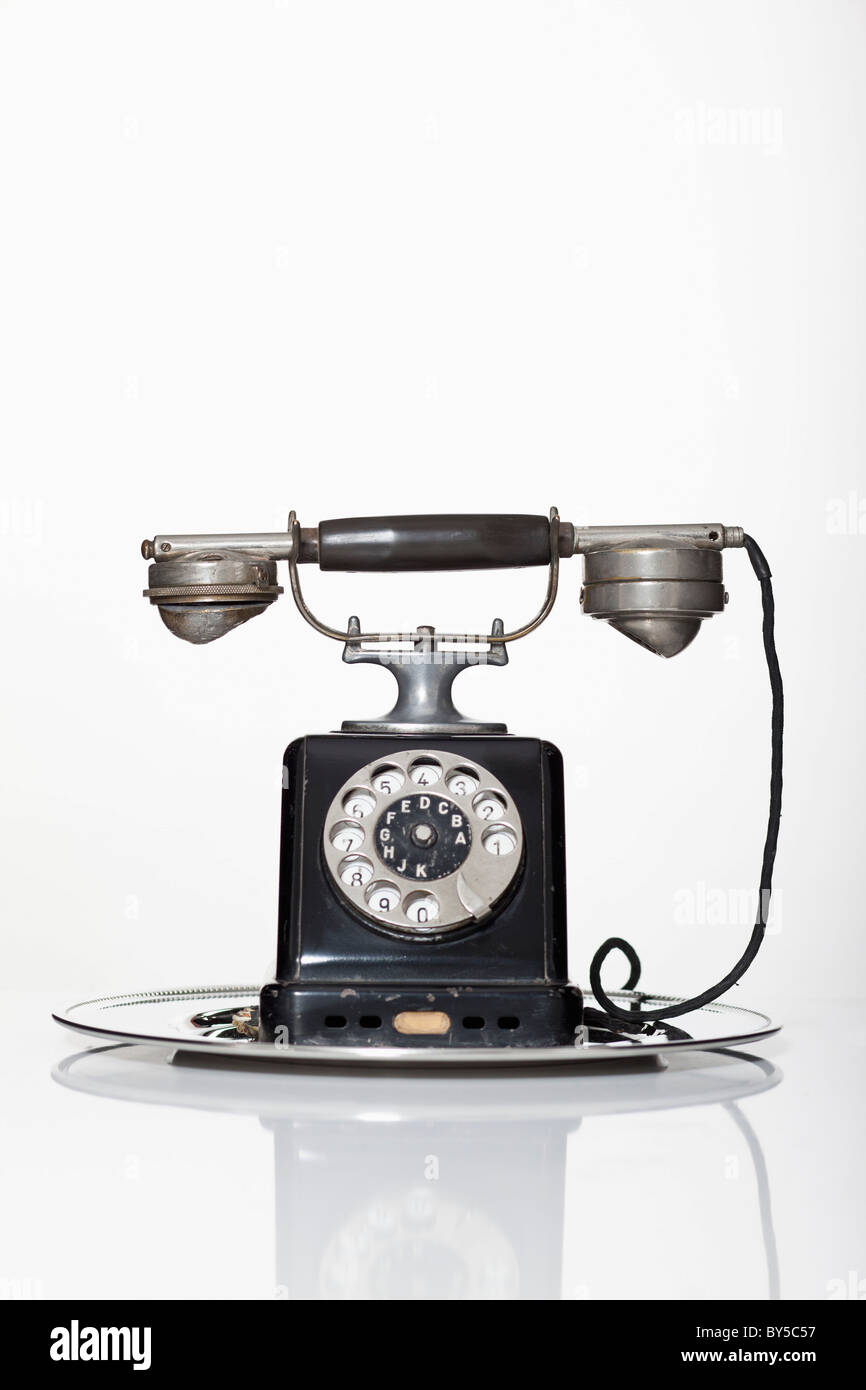 An old-fashioned rotary phone on a silver serving tray Stock Photo