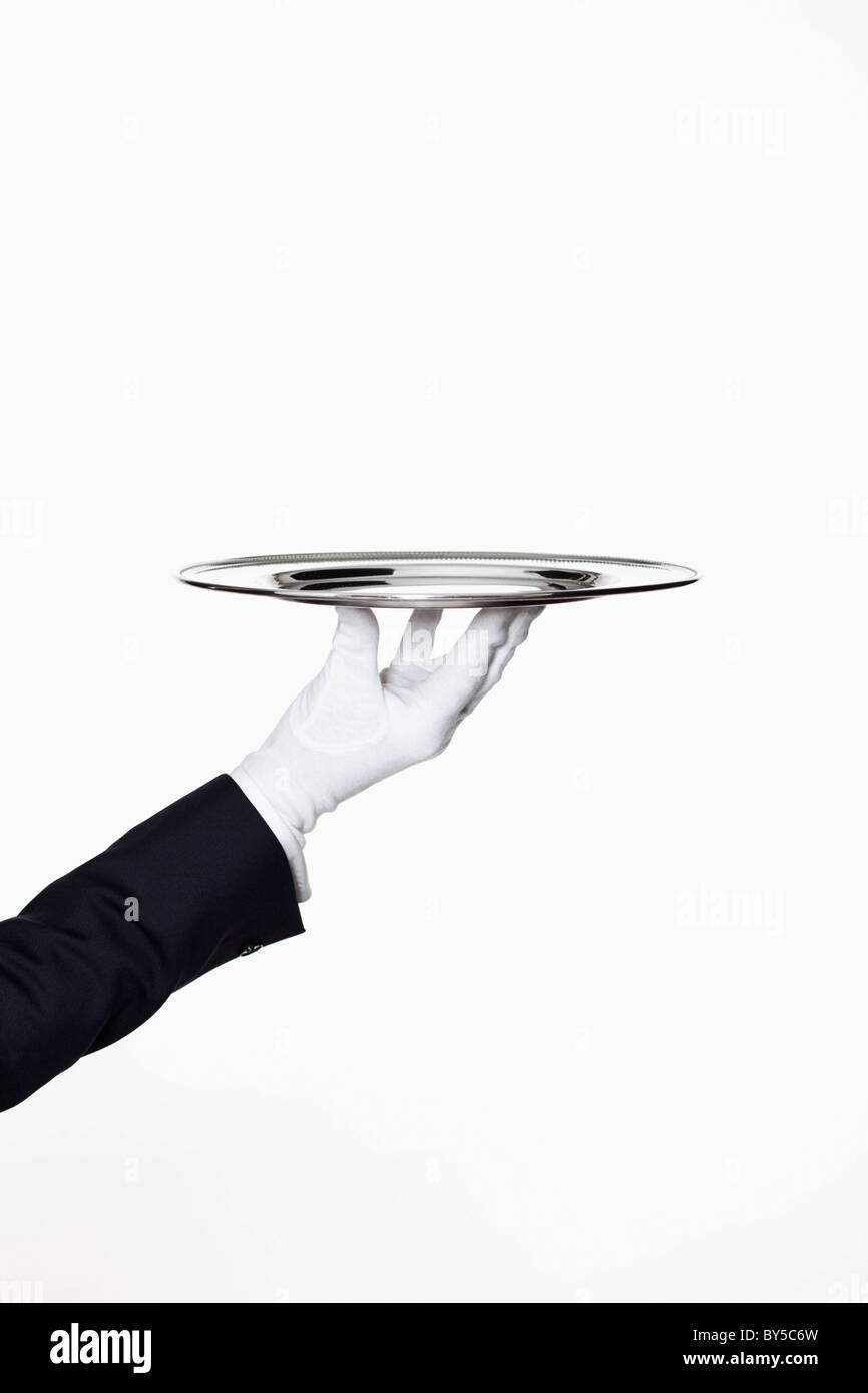 A butler presenting an empty silver tray, focus on hand Stock Photo